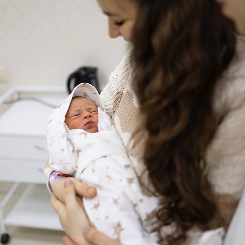 A woman holding her newborn baby