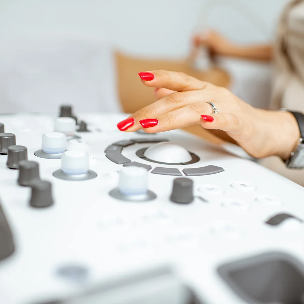 Consultant adjusting ultrasound machine controls