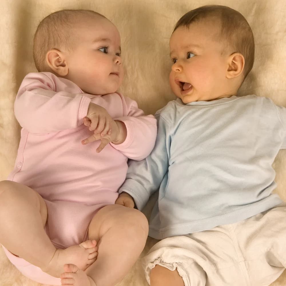 Two newborn babies lying on a blanket