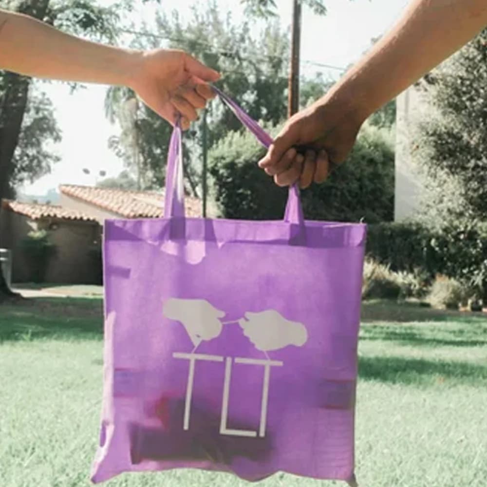 A Little Things Foundation tote bag being handed over
